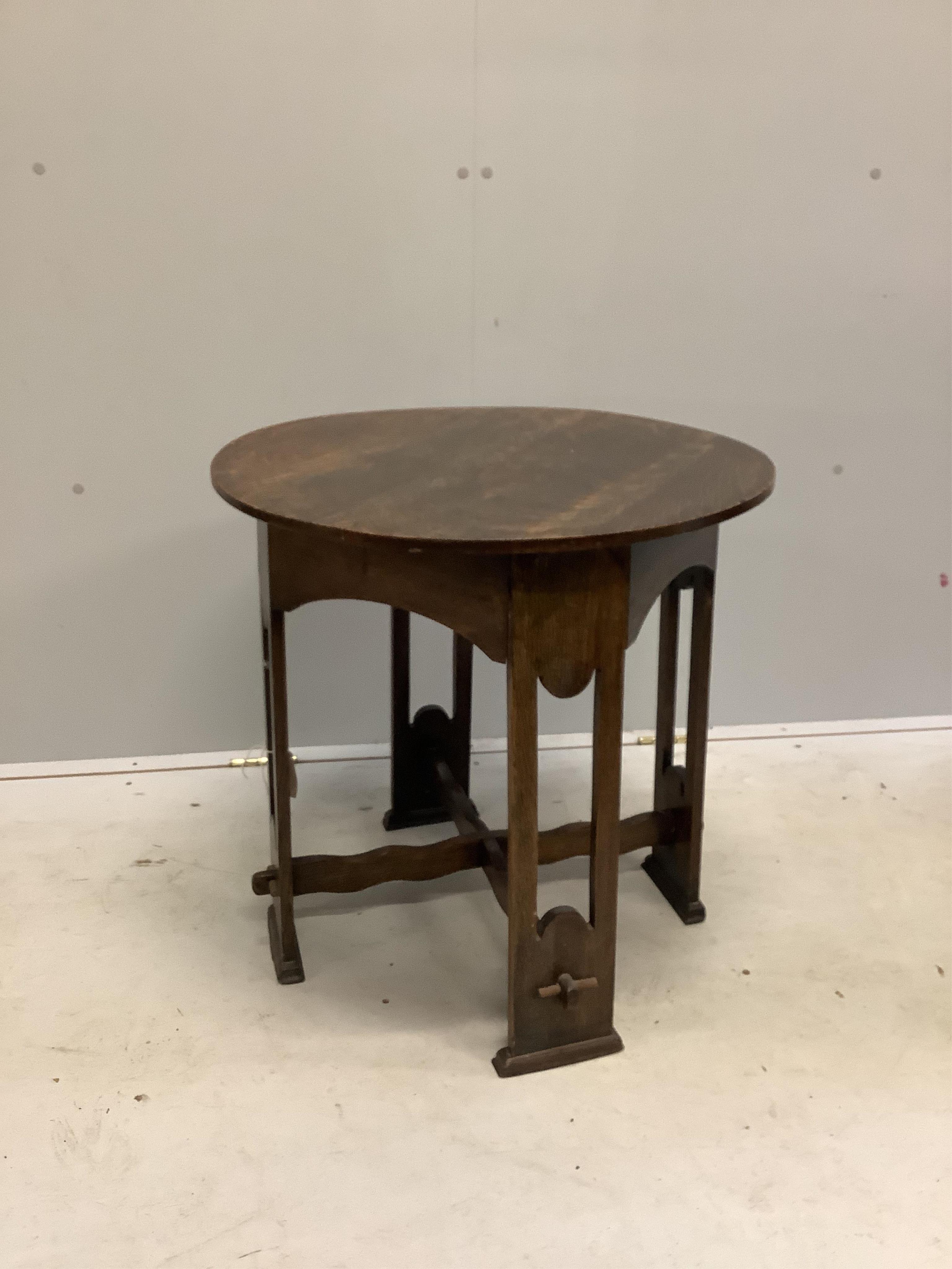 An Arts & Crafts circular oak occasional table, diameter 61cm, height 61cm. Condition - fair